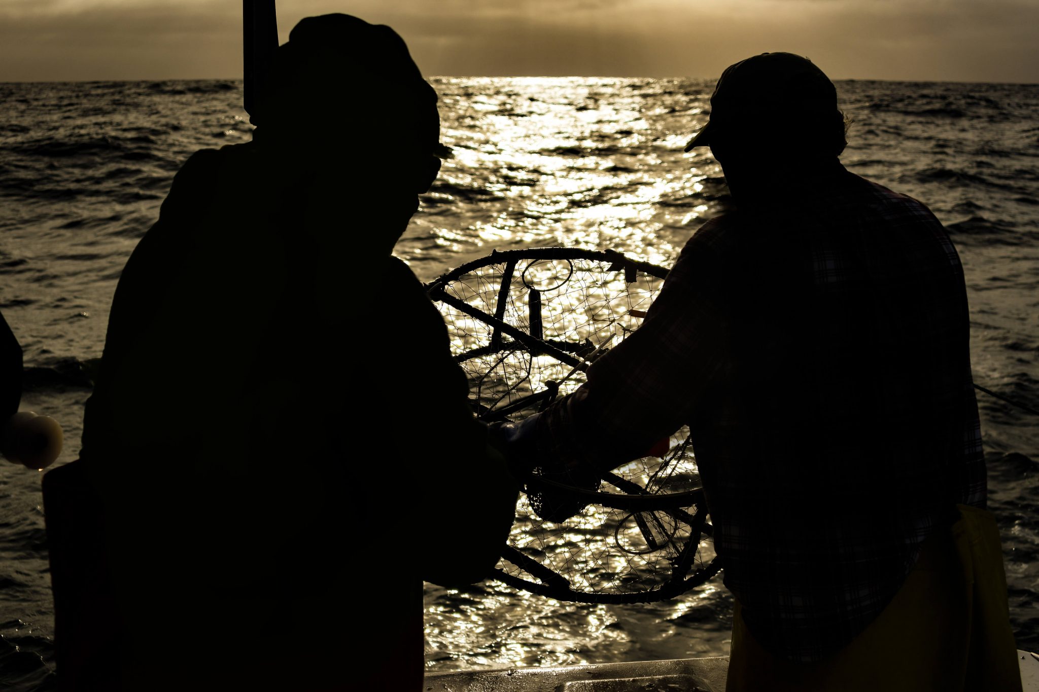 picture of Two crabbers, in silhouette at sunrise
