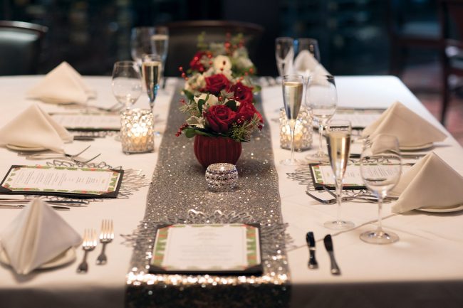 picture of private dining holiday floral centerpiece with red and white roses and holiday greenery