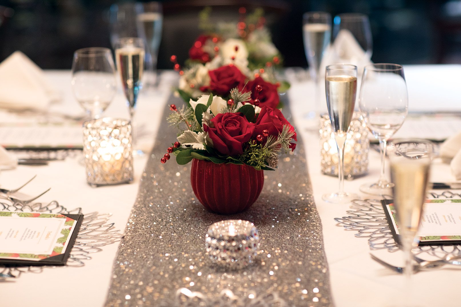 picture of private dining holiday floral centerpiece with red and white roses and holiday greenery