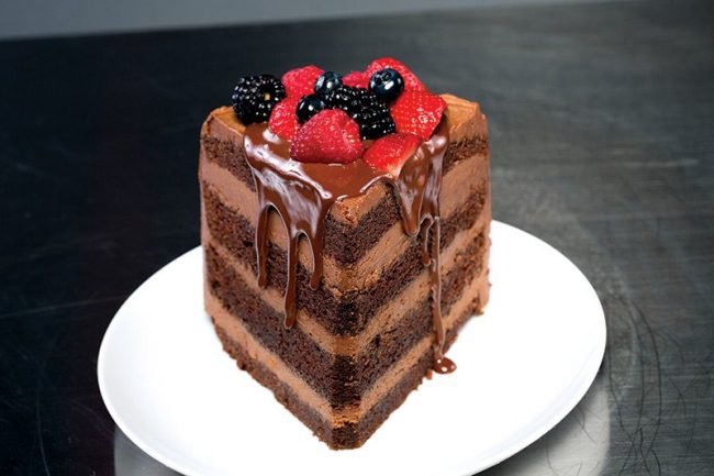 picture of Chocolate malt cake with chocolate malt cream cheese icing drizzled with chocolate ganache and topped with strawberries, blueberries and blackberries