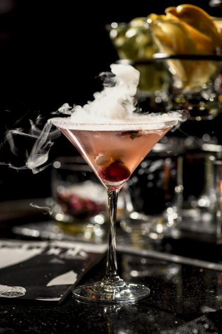 Cocktail in a martini glass with smoke lifting off the top