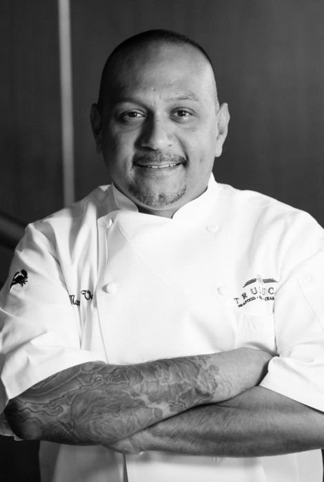 Manuel Vera smiling in his chef's apron