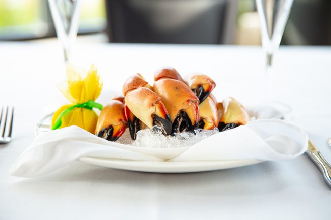 picture of Florida stone crab claws on ice with a wrapped lemon