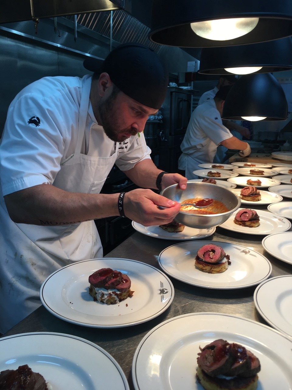 picture of Chef Samir Canaan plating food for a private event.