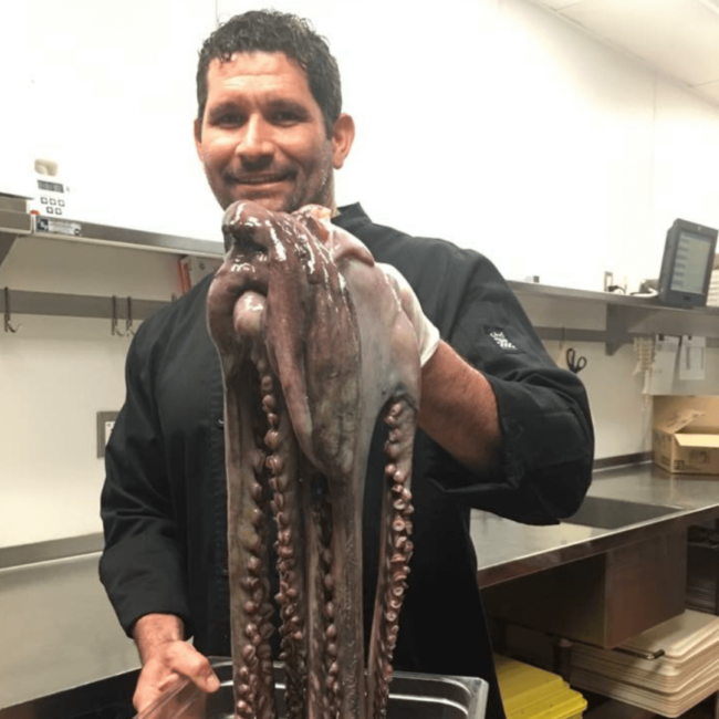 picture of Chef Odel holding a whole fish in the kitchen