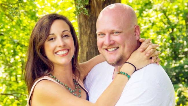 Cary Grider and his wife posing in front of a group of trees